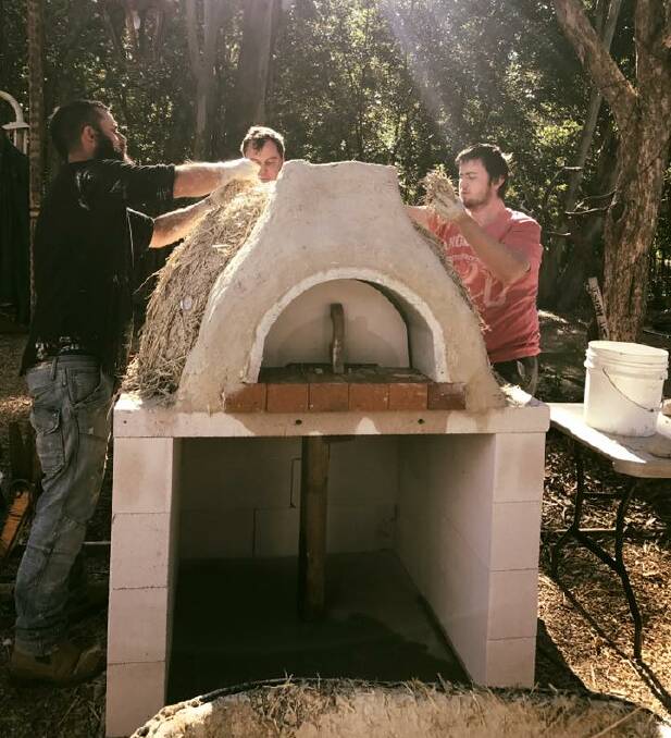 CONSTRUCTION: A joint effort between community, business and MP Matt McEachan results in the creation of a clay cobb pizza oven at The Cage Youth Foundation. Photo: Supplied