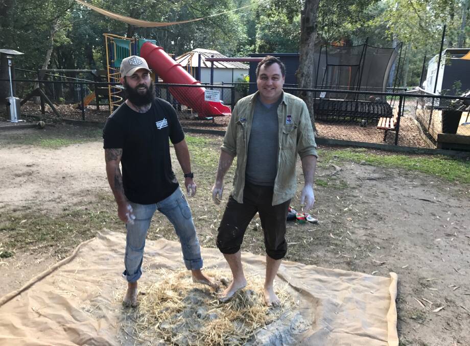 BUILDING: The Cage Youth Foundation's Paul Bower and MP Matt McEachan roll up their sleeves and kick off their shoes to build a clay cobb pizza oven. Photo: Supplied