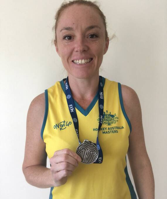 LOCAL: Kylie O'Donohue of Wellington Point in her Australian uniform and holding her Masters Hockey World Cup silver medal. Photo: Lily Spadaro