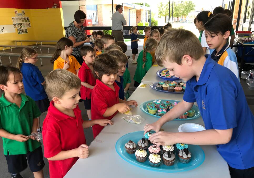RAISING MONEY: Cameron Burow and Jacob Ribeiro serve cupcakes to prep students as part of their efforts to raise money for drought-affected farmers.