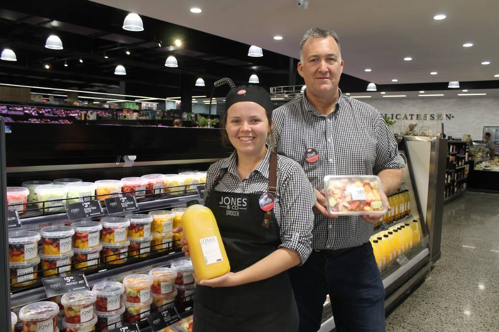 FRESH: Izabella Kennedy and chef, baker and butcher Scott Elliott with freshly squeezed orange juice and cut fruit in the Supa IGA Mount Cotton. Photo: Cheryl Goodenough