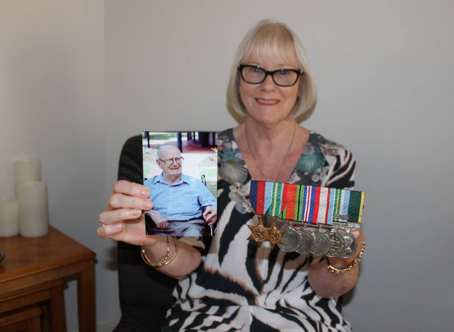 HONOURED: Birkdale resident Libby Parkinson has been awarded a Medal of the Order of Australia. She is holding a picture of her father Colin Clinch, who was a member of the 2/10th Field Regiment and a prisoner of war. Photo: Cheryl Goodenough