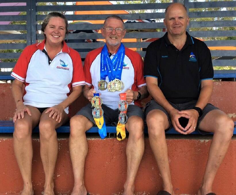 CELEBRATING: Redlands Masters president Sandra Wylie with winner of nine medals Rod Mackenzie and Masters Swimming Queensland president Shane Knight.