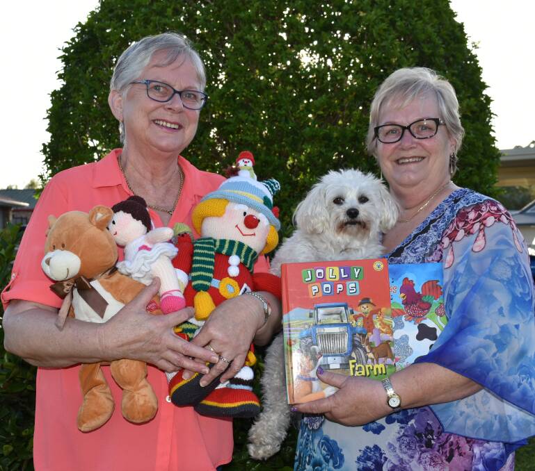 COMMUNITY SPIRIT: Capalaba sisters Jo Verhoeve and Adriana Kuhn with dog Fuzzy and goods they made or collected. Photo: Hannah Baker