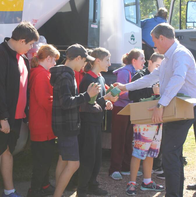 PROMOTING RECYCLING: LNP leader Tim Nicholls hands out miniature rubbish bins to Redland District Special School students at Thornlands. Photo: Cheryl Goodenough