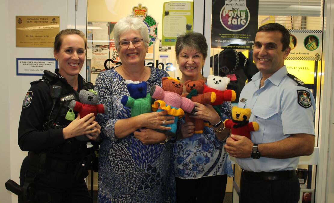 Senior Constable Vrinda McCauley, knitters Rita Metcalfe and Sue Sykes and Senior Sergeant Dave Candale with teddies knitted by members of the Mad about Knitting group.