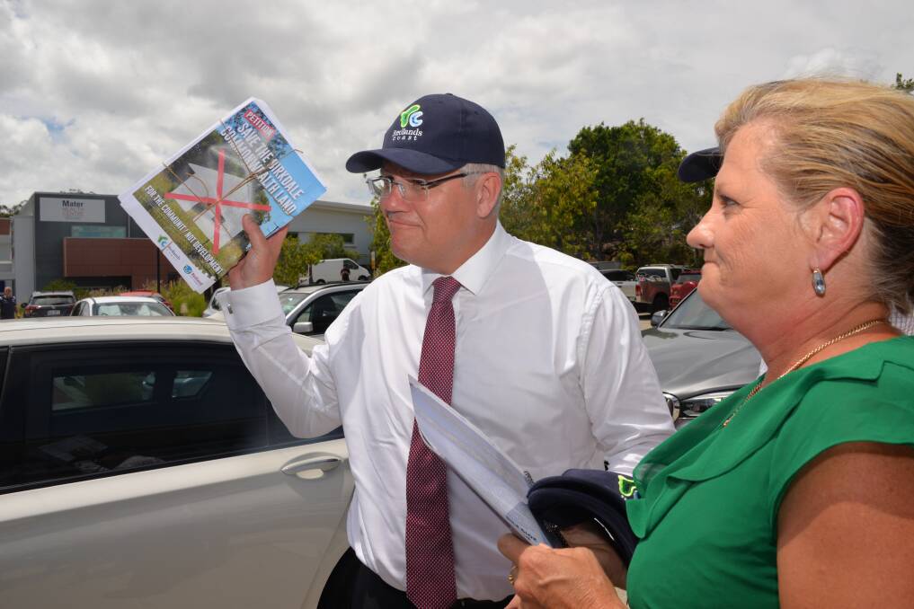 THE PETITION: Prime Minister Scott Morrison holds the petition with about 6500 signatures regarding Birkdale bushland that he received from Redland City mayor Karen Williams while in Cleveland last week. Photo: Brian Williams