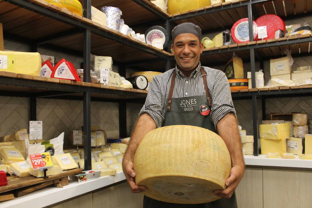 CHEESE ROOM: Supa IGA Mount Cotton chef Neco Linhares carries a 35 kilogram wheel of cheese into the supermarket's fromagerie. Photo: Cheryl Goodenough