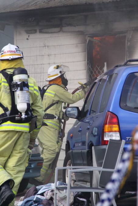 FIGHTING FIRE: Fire crews on the scene of a house fire in Birkdale on Sunday. Photo: Grant Spicer