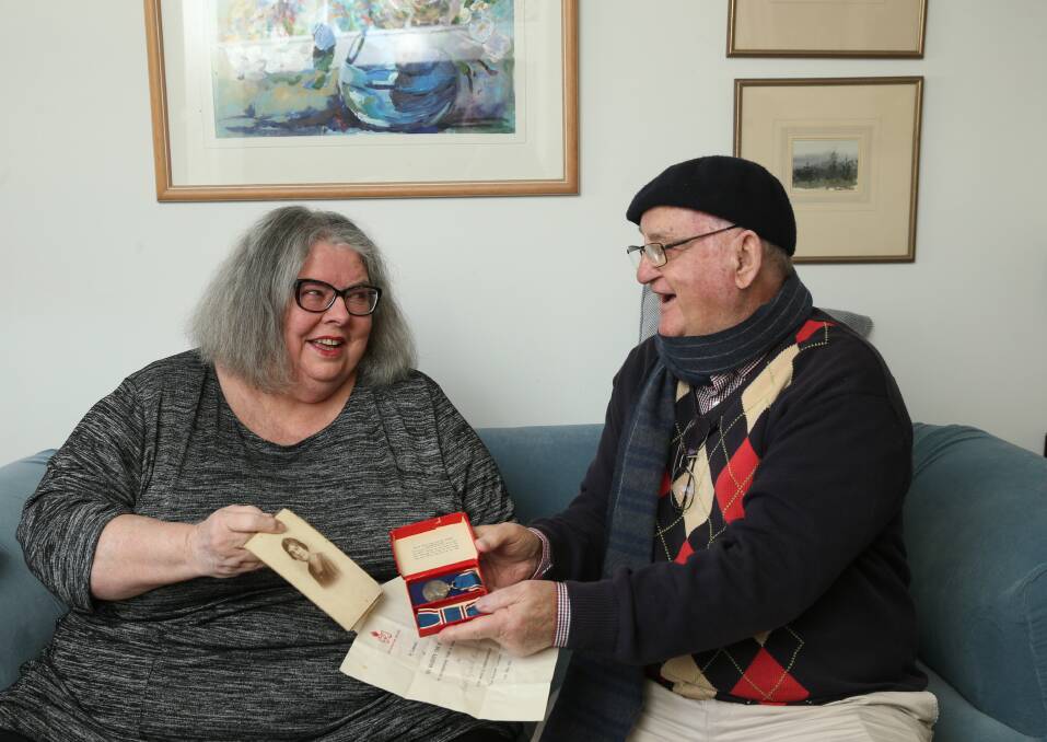 Lost and found: Janet Pollock shows Vic Levi a photograph of her great aunt "Beth", whose King George VI coronation medal was found in a box donated to the Friends of the University Book Fair. Picture: Marina Neil