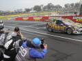 FIRST TIME WINNER: David Reynolds crosses the finish line to win a rain soaked edition of the Bathurst 1000. Photo: CHRIS SEABROOK 