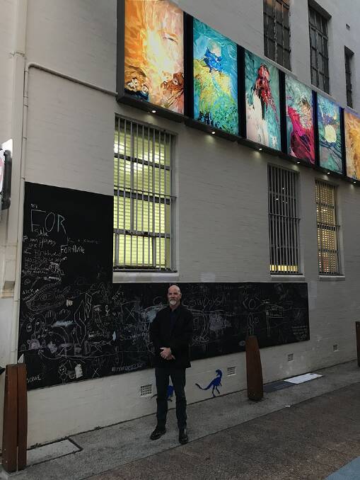 EXHIBITION: Andrew Peachey with his work displayed at Fish Lane, near Grey Street, in Brisbane as part of the Outdoor Gallery Program.