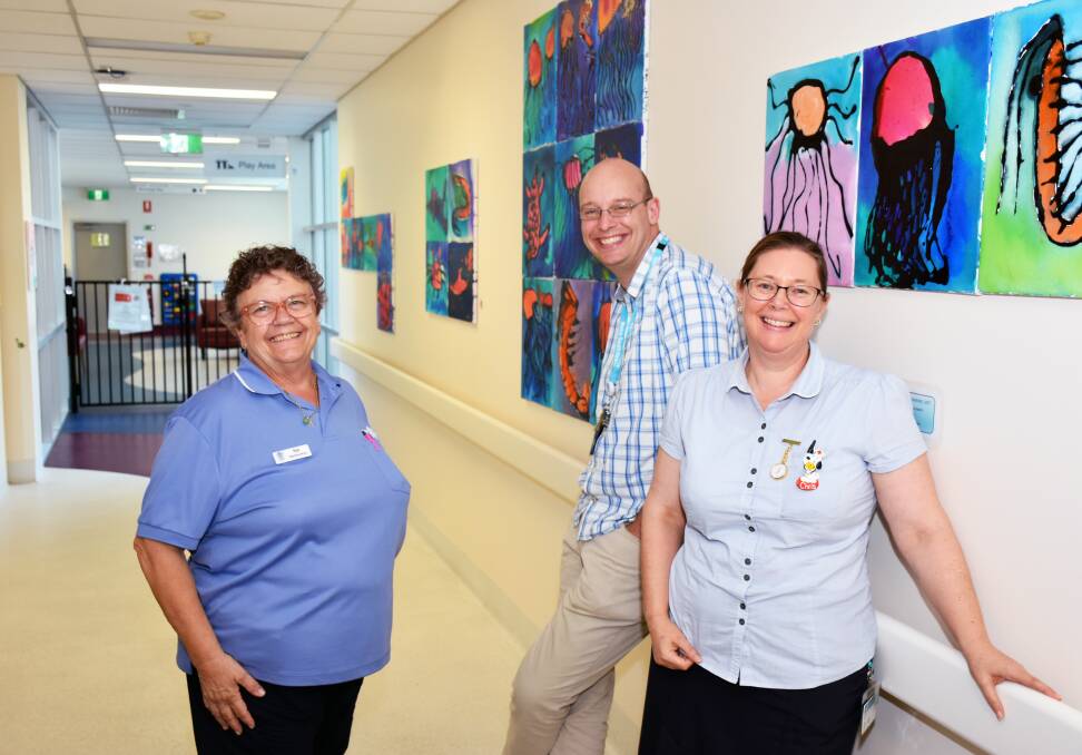 COMMONWEALTH ART: Nurse Sue Gore, Dr Dougie Thomas and nurse Christine Campbell near artwork painted by Queensland children.