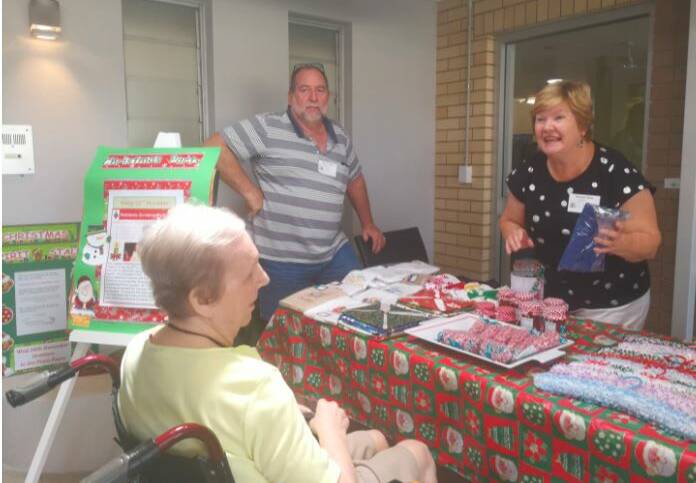 GENEROUS SPIRIT: Resident Helen being served by volunteers Michael and Diane at last year's successful event. Photo: Supplied