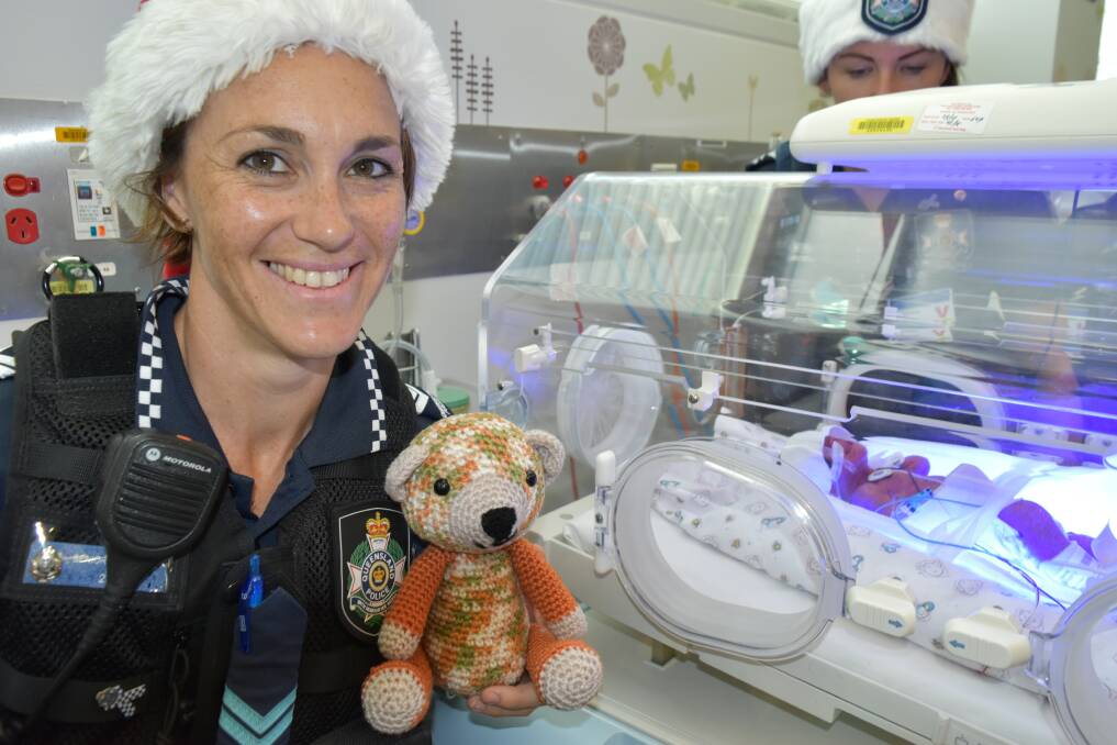 Senior Constable Clara Rizzo stands near a premature baby boy, who has not yet been named. Photo: Hannah Baker  