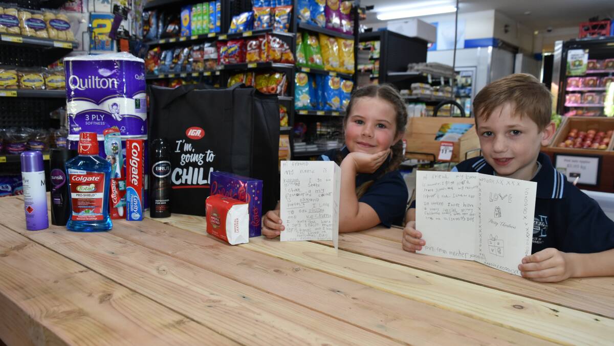 Hilliard State School year one students Hannah and Hunter, both 6, wrote messages in Christmas cards for care pack recipients.