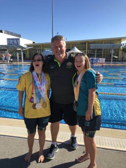 GREAT ACHIEVEMENT: Special Olympians Aliesha Sneesby, 22, and Katrin Culla, 19, with Redlands Special Olympics head swimming coach Craig Tobin. Photo: Supplied