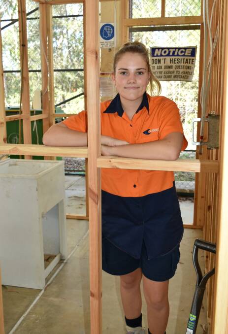 TOP JOB: School-based construction apprentice Lili Leaney stands inside a house frame she helped build at Alexandra Hills TAFE campus. Photo: Hannah Baker
