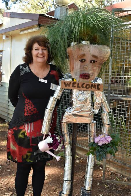 Redlands Floral Art Club president Val Decker with a tin man she made with her husband for the 10th anniversary celebrations. Photo: Supplied