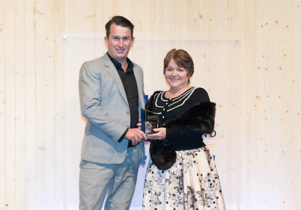 STAR BUILDER: Munro Designed Homes founder and director Chris Munro receives the award from Origin's Kim Sharpe. Photo: Supplied