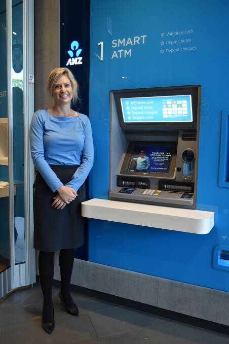 FUTURISTIC: Cleveland ANZ branch manager Erin Cunningham stands in front of the smart ANZ automatic teller machine that accepts deposits and withdrawals. Photo: Hannah Baker