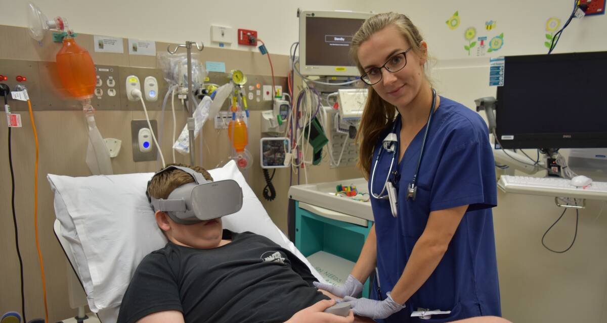 Ryan, 13, wore virtual reality googles to scuba dive and tour a museum as his blood was taken by Dr Palmer for testing. The goggles were delivered to the hospital this month. Photo: Hannah Baker