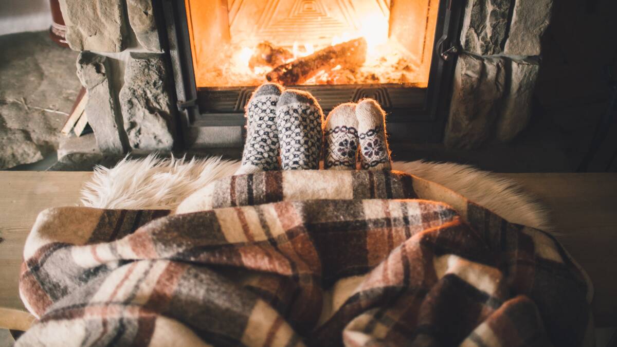 TAKE CARE: These two are snugged up near a fire. People using electrical appliances to keep warm should check for signs of damage before using. Photo: Shutterstock
