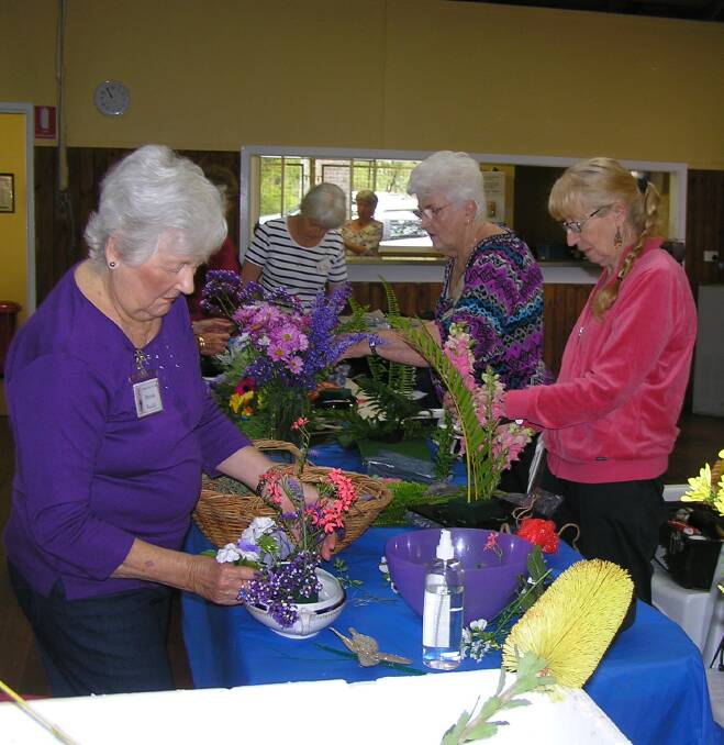 BUSY ELVES: Work is underway at the Redlands Floral Arts Club to prepare more than 60 bouquets for random drops across the region. Photo: Supplied