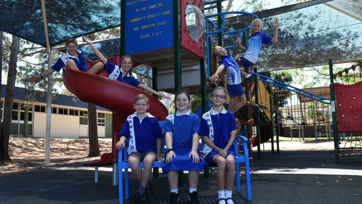 FUN TIMES: Vice school captain Declan Tate, school captain Ella Carmichael, vice school captain Georgia Forchert and school captain Kiera Knott play behind grade three and four students William Smith, Charlotte Lloyd and Scarlett Jepson. The three younger students, who have offered to befriend lonely kids, sit on the new buddy bench.