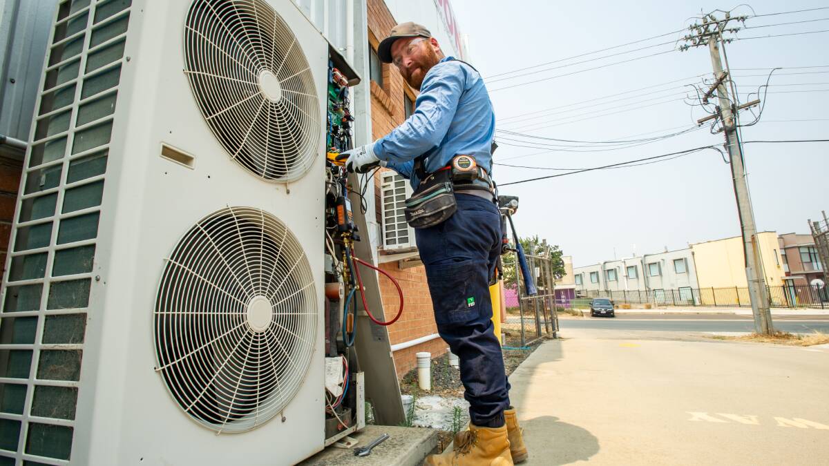 KEEPING COOL: An airconditioning technician works on a unit during a busy summer. Picture: Karleen Minney
