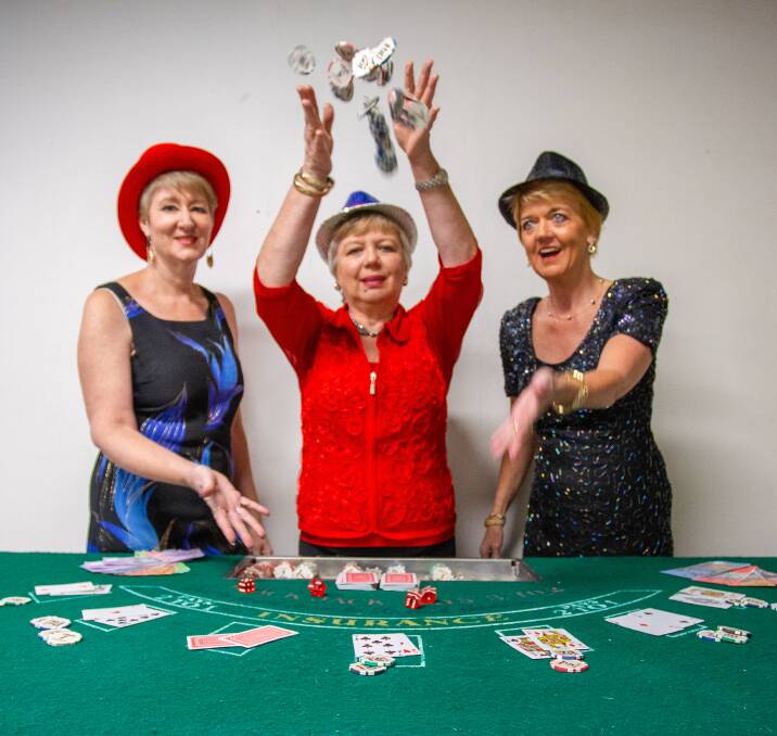 CASINO:President Redlands branch of Cancer Council Queensland Tish Henderson of Mount Cotton, treasurer Belinda Kuppens of Birkdale andvice president Carol Underwood of Cleveland pick up a few tips in preparation for a fund raising casino night.
