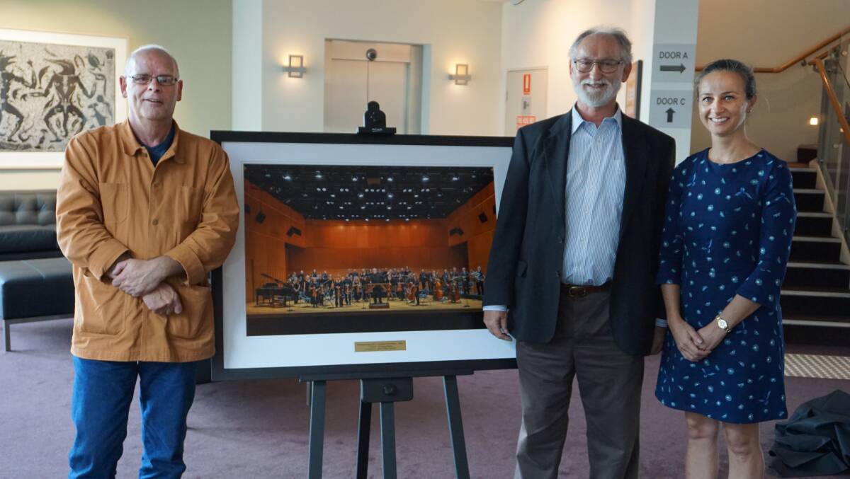 PHOTO: Former Creative Arts manager Zane Trowe receives this framed photograph celebrating five years of residence from the Redland Sinfonia with conductor Dr Graeme Denniss and photographer Marija Sullavan.