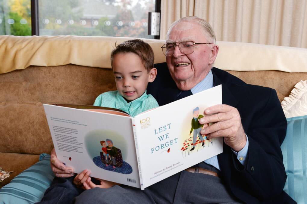 READING: Oscar Kosloff bought his favourite book, Lest We Forget, when he met Tom Rush for the first time after the Anzac Day parade in 2016. Picture: Kate Healy