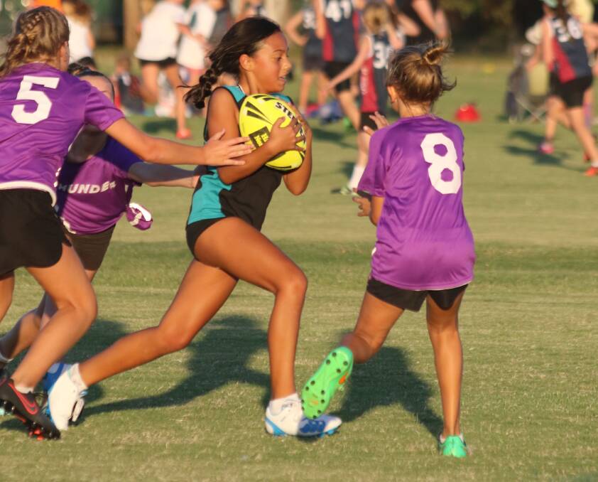 Hayley Bush, Code Black, takes on the Thunder defence during the kick off of the Redlands Touch Football season at the weekend.