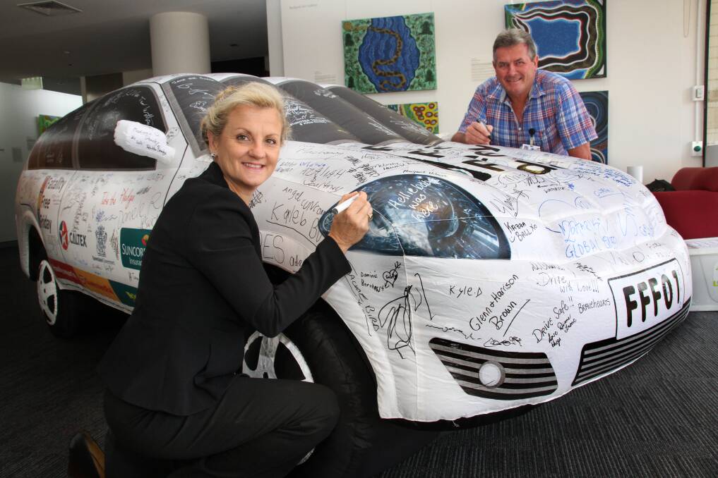 Mayor Karen Williams and Cr. Murray Elliott sign the Fatality Free Friday inflatable car at Redland City Council.Phot by Chris McCormack