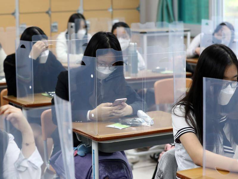 Senior students have returned to class in South Korea under strict virus safety measures.