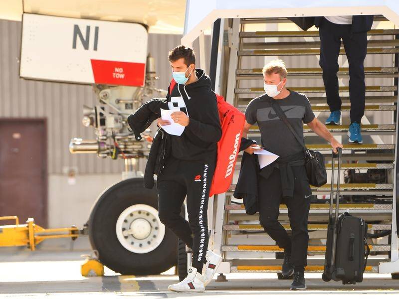 The first of 15 charter flights carrying tennis players and officials has touched down in Melbourne.