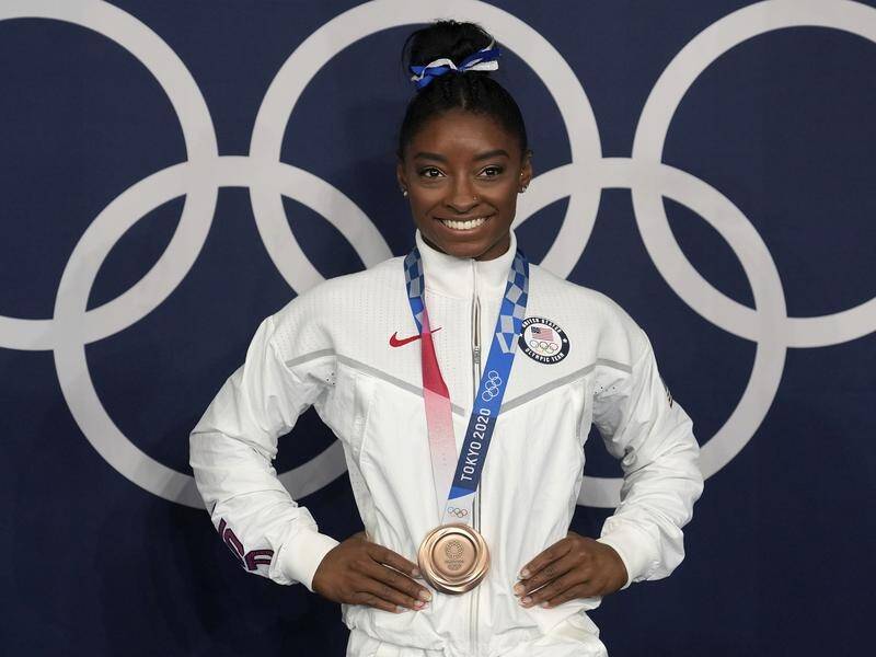 Gym star Simone Biles has returned home to the US after winning two medals at the Tokyo Olympics.
