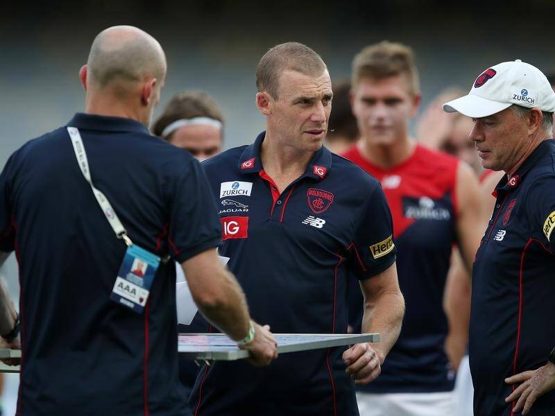 Melbourne coach Simon Goodwin (centre) agrees with the AFL's decision to temporarily close up shop.