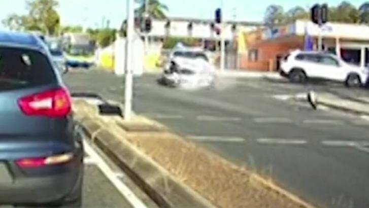 Dashcam captures the moment a driver crashes into a police car at an intersection in Stafford, Queensland on Friday morning. Photo: 7 News Queensland