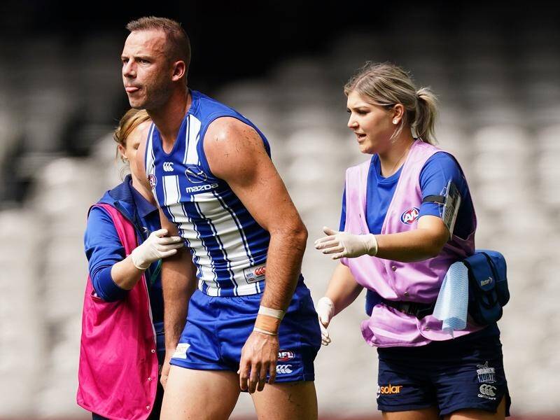 Josh Walker of the Kangaroos leaves the field after his fall in the match against St Kilda.