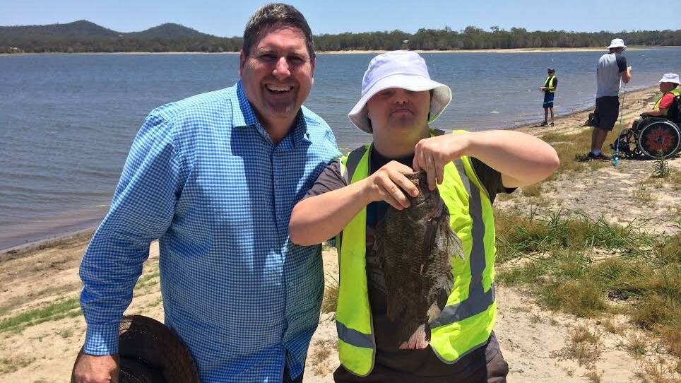 Capalaba MP Steve Davies congratulates this angler who helped rid Leslie Harrison Dam of pest tilapia fish on Friday. 