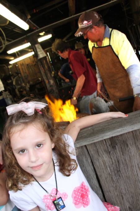 Redland Museum Open Day and official opening of the Australian Toy Hall of Fame: Mary Hoskins, 5, of Gladstone, watches the blacksmiths at work. Photo by Chris McCormack