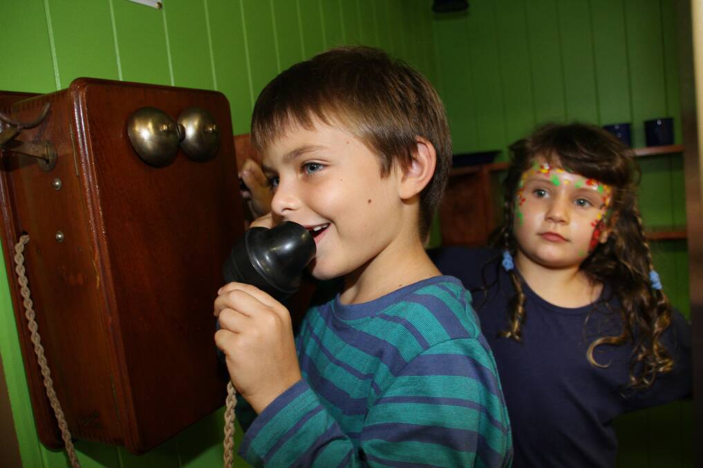 Redland Museum Open Day and official opening of the Australian Toy Hall of Fame: Zephyr Bishop, 8, of Birkdale, and Eleanor Richards, 6, of Cleveland, discover what telephones once looked like. Photo by Chris McCormack