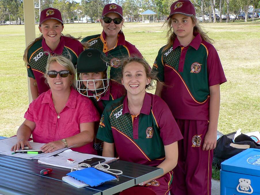 BIG HITTERS: Players from Redlands Women’s 2nd Grade team checking the score book in their game against Sandgate/Redcliffe last Sunday.