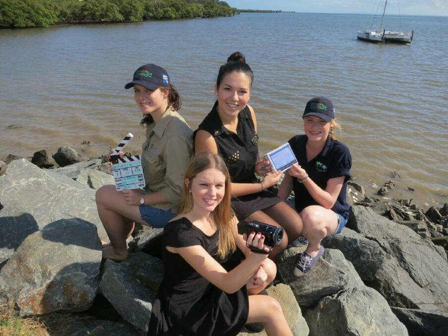 Film-makers Emily McHenry (front) of Ormiston and Alana Irving (centre back), of Cleveland, hand their Cicada Award entry to Wildlife Queensland community science officers Emma Watson (left) and Alix Baltais on Ormiston foreshore, a location featured in the girls short film, We all C.A.N. Conserve Aquatic Nature. 
Photo courtesy WPSQ Bayside Branch