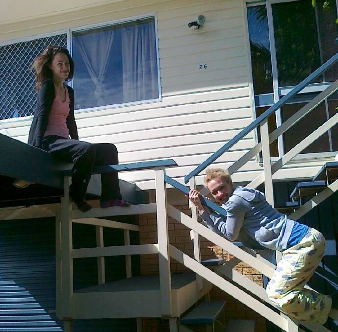 Singer Jac Stone sits on the roof while her sister Sam slides down the stair rail at their Redland Bay home.