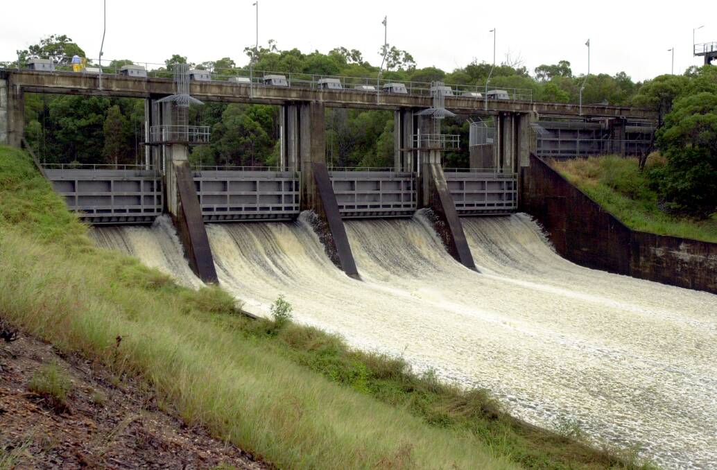 Water flows down the spillway as the gates open.