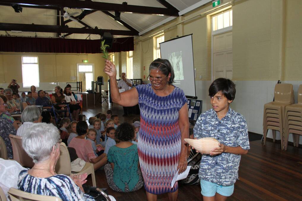 Quandamooka elder Evelyn Parkin and her grandson Preston Cockatoo-Collins conduct a water blessing on the people at the Dunwich Public Hall centenary celebrations.