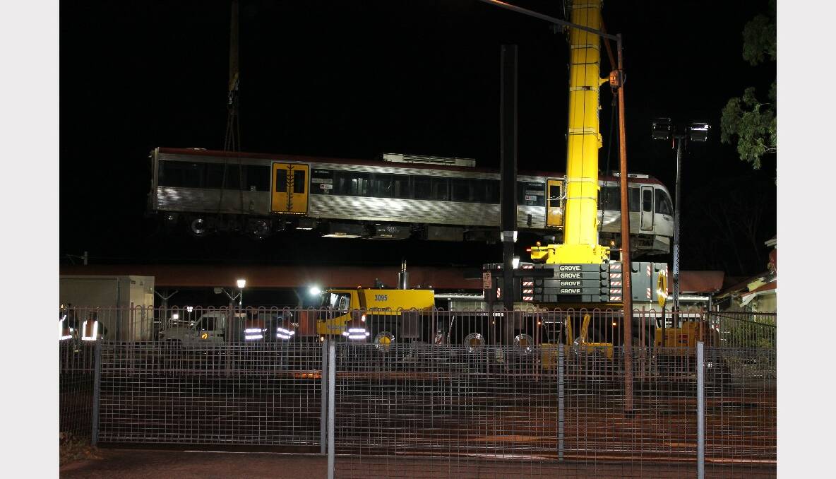 The front carriage of the crashed train is lifted out of the station building.